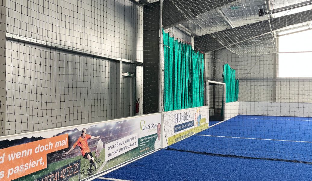 Mehrzweckhalle mit blauem Boden und Werbebanden
