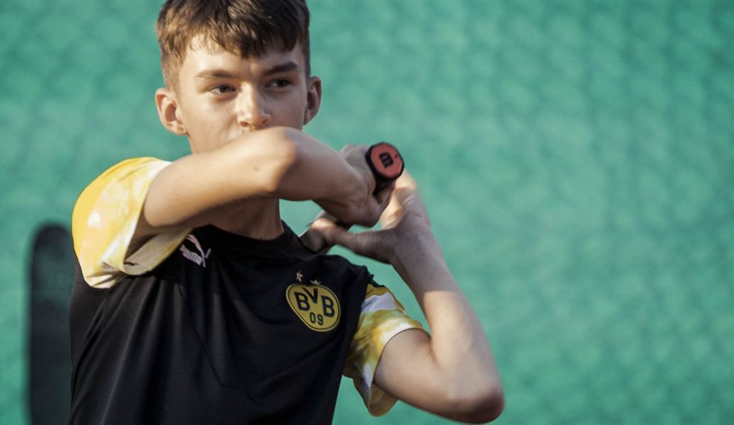 Eine Junge mit einem Tennisschläger in der Hand