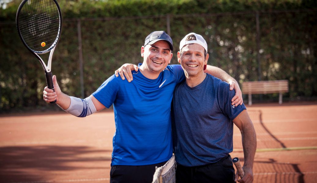 Zwei Personen die Tennisschläger in der Hand halten
